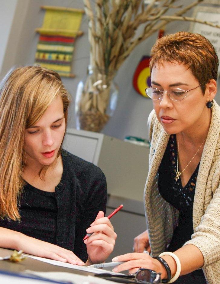 tutor helps a student in a classroom